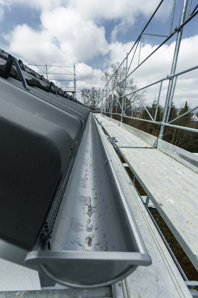 Gros plan sur l'installation d'une nouvelle gouttière de toit