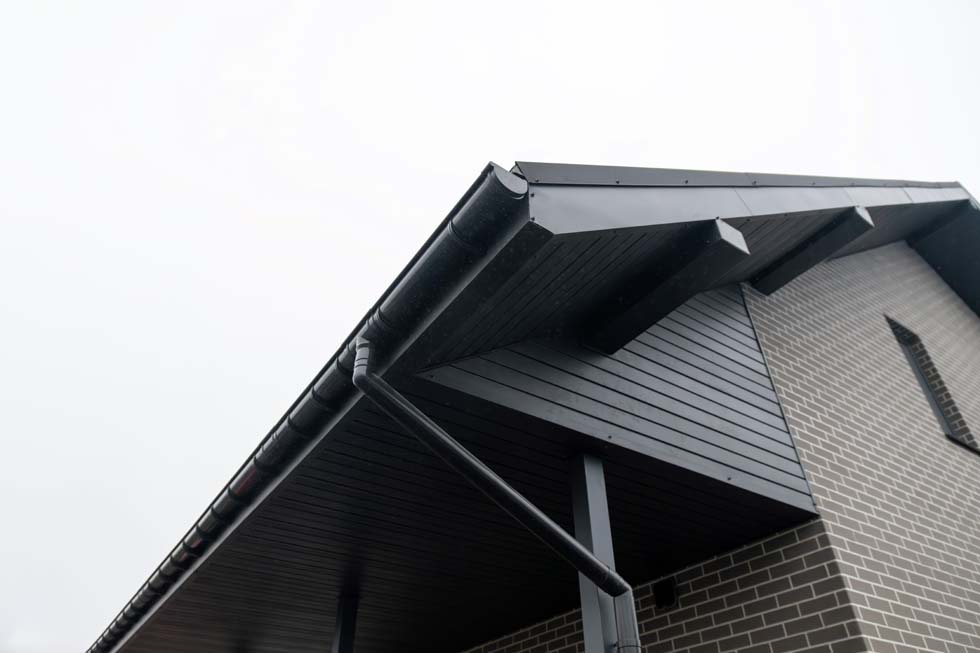 Système de gouttière en PVC noir avec descente pluviale