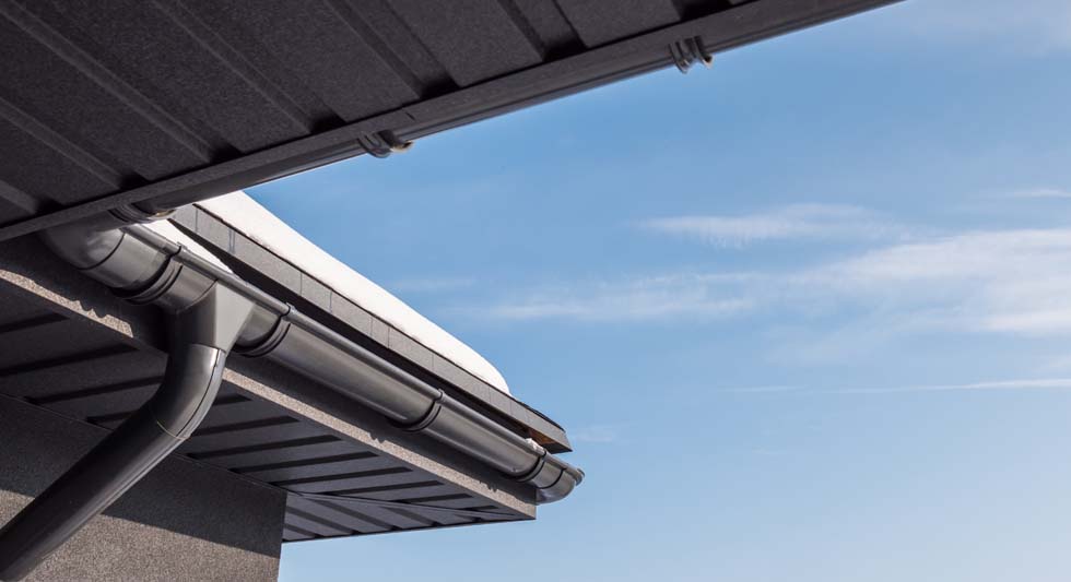 Le coin du toit muni d'un système d'évacuation des eaux pluviales est recouvert de neige.